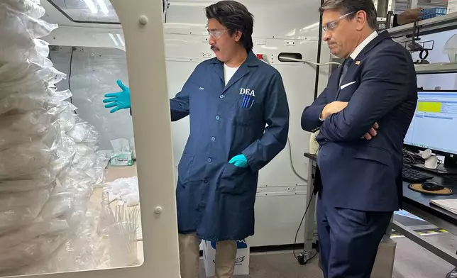Acting Attorney General Todd Blanche talks to a technician in a Drug Enforcement Administration (DEA) mobile lab who is running tests on seized drugs in Phoenix, Wednesday, May 6, 2026. (AP Photo/Rebecca Santana)