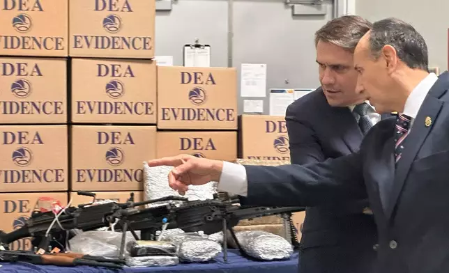 Acting Attorney General Todd Blanche looks at weapons and drugs that were seized by federal officers, with Drug Enforcement Administration special agent in charge Apolonio Ruiz, Jr., at a warehouse in Phoenix, Wednesday, May 6, 2026. (AP PhotoRebecca Santana)