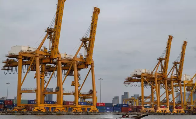 A small boat splashes past a row of ship-to-shore cranes at Khlong Toei Pier in Bangkok, Thailand on Jan 3, 2026. (AP Photo/Anton L. Delgado)
