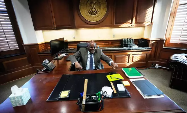 Calvin Duncan, left, an exoneree who was elected Orleans Parish clerk of criminal court, gets behind his desk on the first day of his term, Monday, May 4, 2026, in New Orleans. (AP Photo/Gerald Herbert)