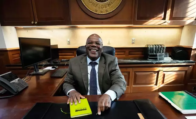 Calvin Duncan, left, an exoneree who was elected Orleans Parish clerk of criminal court, gets behind his desk on the first day of his term, Monday, May 4, 2026, in New Orleans. (AP Photo/Gerald Herbert)