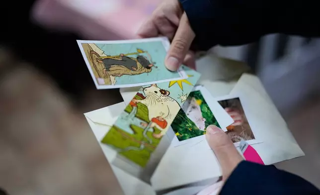 Visitors look at photos of rats during Ratapalooza, an event promoting the adoption and responsible care of former laboratory rats and mice, in Buenos Aires, Argentina, Sunday, May 17, 2026. (AP Photo/Natacha Pisarenko)