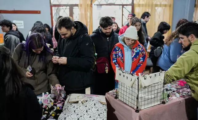 People look at stands selling rat merchandise during Ratapalooza, an event promoting the adoption and responsible care of former laboratory rats and mice, in Buenos Aires, Argentina, Sunday, May 17, 2026. (AP Photo/Natacha Pisarenko)