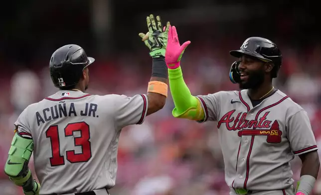 Atlanta Braves' Ronald Acuña Jr. left, celebrates after hitting a solo home run with Michael Harris II, right, during the first inning of a baseball game against the Cincinnati Reds in Cincinnati, Friday, May 29, 2026. (AP Photo/Carolyn Kaster)