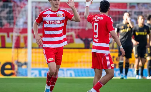 Union Berlin's Tom Rothe, left, celebrates after scoring his side's first goal during the German Bundesliga soccer match between 1. FC Union Berlin and 1. FC Köln. (Soeren Stache/dpa via AP)