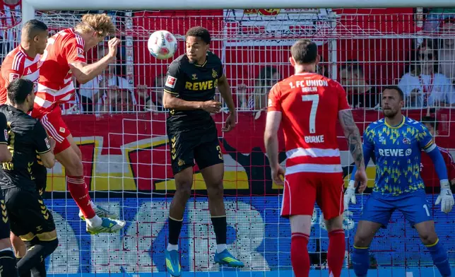 Union Berlin's Tom Rothe, third from left, scores his side's first goal during the German Bundesliga soccer match between 1. FC Union Berlin and 1. FC Köln. (Soeren Stache/dpa via AP)