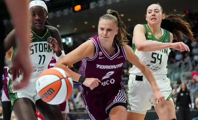 Toronto Tempo forward Laura Juskaite (2) chases down a loose ball as Seattle Storm forward MacKenzie Holmes (54) and teammate Awa Fam (11) look on during a WNBA basketball game in Toronto, Saturday, May 30, 2026. (Frank Gunn/The Canadian Press via AP)