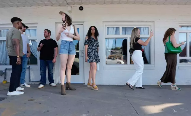 Celina Vilcinskas, center left, who is 6 feet, 8 inches tall, waits in line to enter a Tall Tour event Saturday, May 9, 2026, in Austin, Texas. (AP Photo/David J. Phillip)