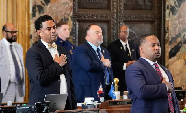 Louisiana Reps. Adrian Fisher, D-Dist 16, left, Chad Michael Boyer, R-Dist 46, and C. Travis Johnson, D-Dist 21, right, recite the pledge of allegiance prior to a house vote on a redistricting plan to eliminate a majority-Black congressional district in response to a U.S. Supreme Court ruling, in Baton Rouge, La., Thursday, May 21, 2026. (AP Photo/Gerald Herbert)