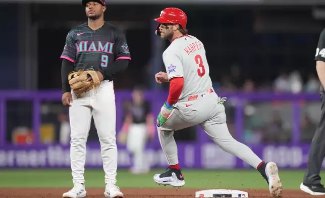 Philadelphia Phillies' Bryce Harper (3) steals second base as Miami Marlins second baseman Xavier Edwards (9) looks on in the fifth inning of a baseball game, Friday, May 1, 2026, in Miami. (AP Photo/Jim Rassol)