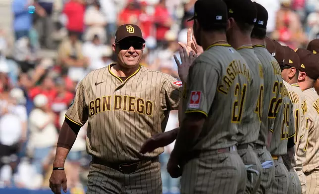San Diego Padres' coach Craig Stammen, left, enters the field prior to a baseball game against Arizona Diamondbacks in Mexico City, Saturday, April 25, 2026. (AP Photo/Fernando Llano)