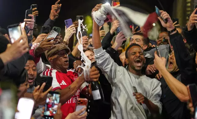 Former Arsenal player Ian Wright celebrates with Arsenal supporters at the Arsenal stadium after Arsenal's soccer team won the Premier League title in London, Tuesday, May 19, 2026.(AP Photo/Alberto Pezzali)