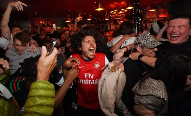 Arsenal supporters celebrate in a pub near the Arsenal stadium after Arsenal's soccer team won the Premier League title in London, Tuesday, May 19, 2026.(AP Photo/Alberto Pezzali)