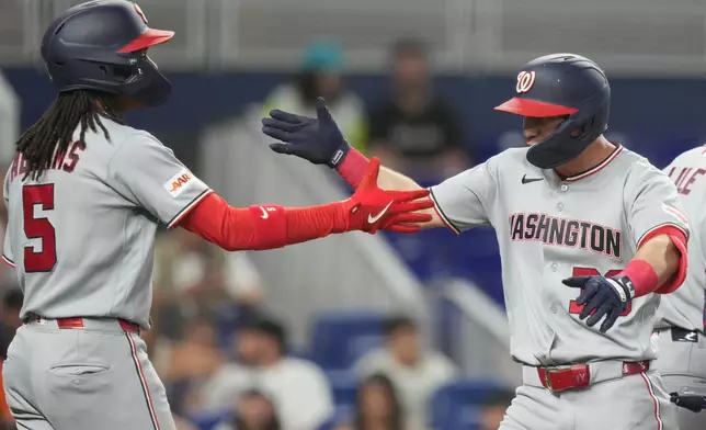 Washington Nationals' Jacob Young (30) is met by CJ Abrams (5) after hitting a two run home run during the first inning of a baseball game against the Miami Marlins, Friday, May 8, 2026, in Miami. (AP Photo/Lynne Sladky)