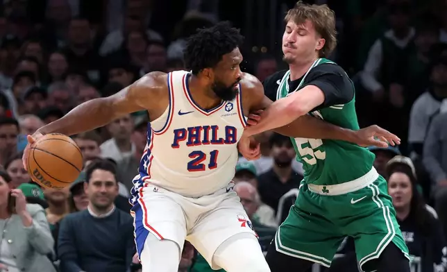Boston Celtics' Jayson Baylor Scheierman (right) defends agianst Philadelphia 76ers' Joel Embiid (left) during the first half of Game 7 in a first-round NBA basketball playoffs series, Saturday, May 2, 2026 in Boston. (AP Photo/Jim Davis)
