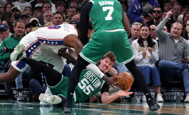 Boston Celtics' Baylor Scheierman gets off a pass as he battles with the Philadelphia 76ers' Paul George during the first half of Game 7 in a first-round NBA basketball playoffs series, Saturday, May 2, 2026 in Boston. (AP Photo/Jim Davis)