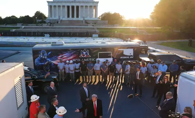 President Donald Trump talks as he visits the Lincoln Memorial Reflecting Pool to see the new blue protective coating being applied as part of a renovation project, Thursday, May 7, 2026, in Washington. (AP Photo/Mark Schiefelbein)