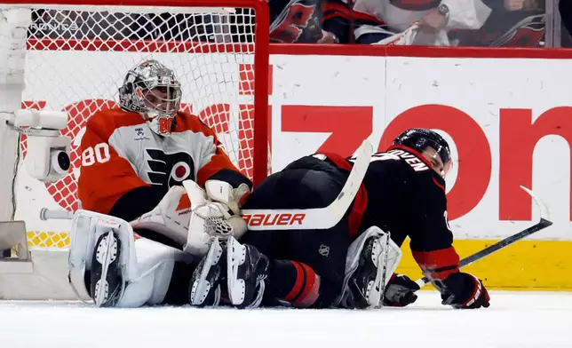 Carolina Hurricanes' Logan Stankoven, right, collides with Philadelphia Flyers goaltender Dan Vladar (80) during the third period of Game 2 of an NHL hockey Stanley Cup second-round playoff series in Raleigh, N.C., Monday, May 4, 2026. (AP Photo/Karl DeBlaker)