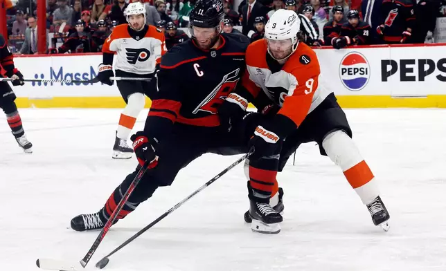 Carolina Hurricanes' Jordan Staal (11) battles Philadelphia Flyers' Jamie Drysdale (9) for the puck during the second period of Game 2 of an NHL hockey Stanley Cup second-round playoff series in Raleigh, N.C., Monday, May 4, 2026. (AP Photo/Karl DeBlaker)