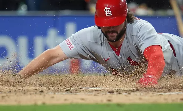 St. Louis Cardinals' Alec Burleson slides in to score from third off a sacrifice fly by Masyn Winn during the fifth inning of a baseball game against the San Diego Padres Friday, May 8, 2026, in San Diego. (AP Photo/Gregory Bull)
