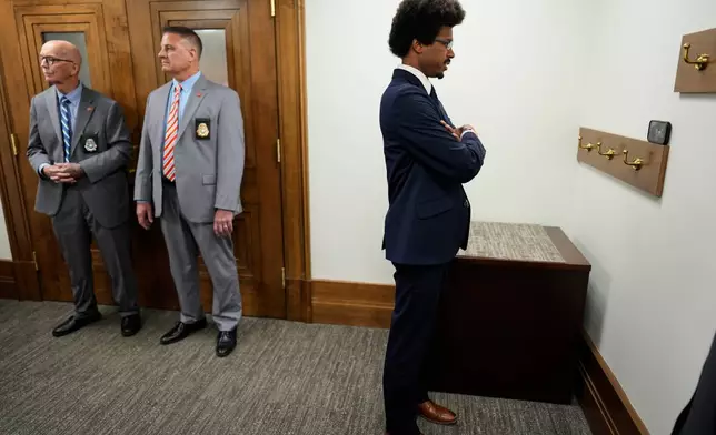 Rep. Justin J. Pearson, D-Memphis, watches a Senate Judiciary committee meeting on his phone outside the hearing room during a special session of the state legislature to redraw U.S. Congressional voting maps Wednesday, May 6, 2026, in Nashville, Tenn. (AP Photo/George Walker IV)