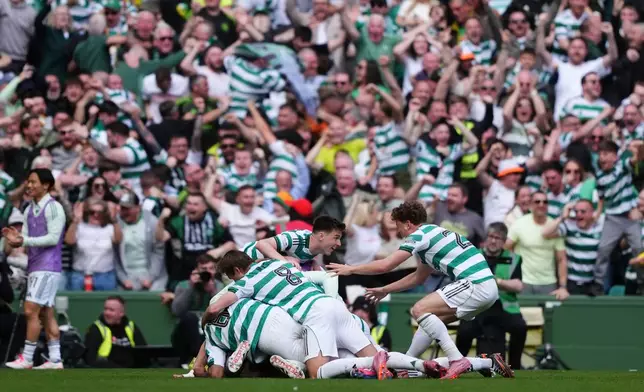 Celtic's Daizen Maeda (hidden) celebrates with team-mats after scoring their side's third goal during the Scottish Premiership soccer match between Celtic and Rangers, in Glasgow, Sunday May 10, 2026. (Steve Welsh/PA via AP)