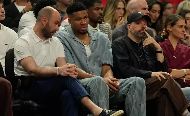 Greece's basketball head coach Vasileios Spanoulis, left, speaks with Giannis Antetokounmpo of the Milwaukee Bucks next to the Oscar nominated director Yorgos Lanthimos during the Euroleague final basketball match between Olympiacos and Real Madrid in Athens, Greece, Sunday, May 24, 2026. (AP Photo/Thanassis Stavrakis)