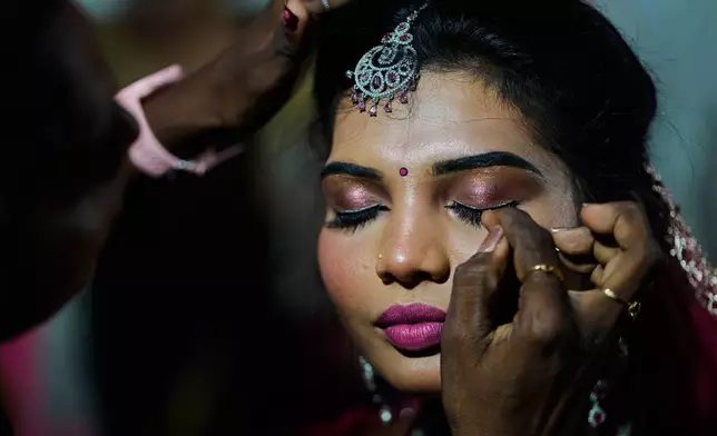 A transgender participant gets ready before taking part in Miss Koovagam 2026 beauty pageant during Koovagam festival in Villupuram, India, Monday, April 27, 2026. (AP Photo/Mahesh Kumar A.)