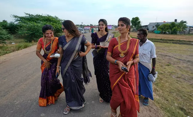 Nazariya Kutty, second right, with her friends arrive to participate in the Koovagam transgender festival in Kallakurichi district, in the southern Indian state of Tamil Nadu, Tuesday, April 28, 2026. (AP Photo/Mahesh Kumar A.)