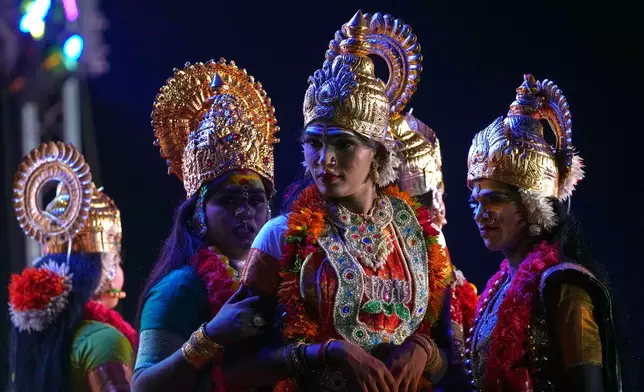 Shanshi, center, and other transgender participants prepare to perform a dance sequence during a beauty pageant at the Koovagam festival in Villupuram, Tamil Nadu, India, Sunday, April 26, 2026. (AP Photo/Mahesh Kumar A.)
