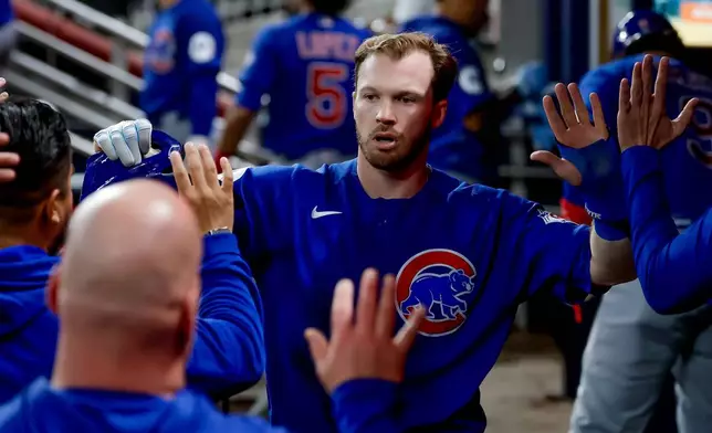 Chicago Cubs' Ian Happ is greeted in the dugout after scoring against the Atlanta Braves during the sixth inning of a baseball game, Thursday, May 14, 2026, in Atlanta. (AP Photo/Erik S. Lesser)