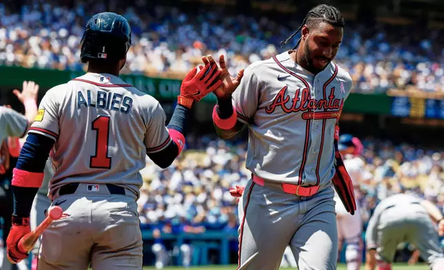Atlanta Braves' Jorge Mateo, right, is greeted by Ozzie Albies (1) on a a two-run double by Atlanta Braves' Mauricio Dubon during the second inning of a baseball game against the Los Angeles Dodgers, Sunday, May 10, 2026, in Los Angeles. (AP Photo/Caroline Brehman)