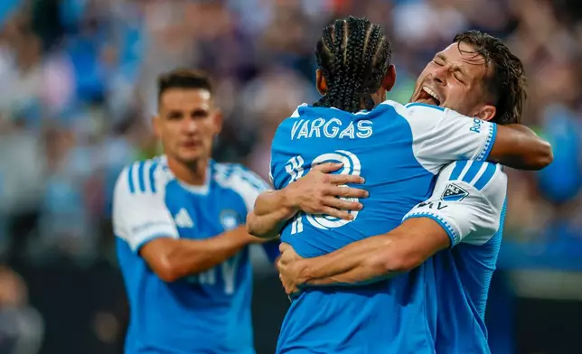 Charlotte FC midfielder Brandt Bronico, right, hugs forward Kerwin Vargas, front left, after a goal against Toronto FC during the first half of an MLS soccer match in Charlotte, N.C., Saturday, May 16, 2026. (AP Photo/Nell Redmond)