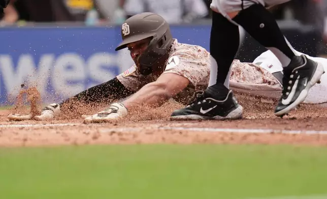 San Diego Padres' Xander Bogaerts slides in to score from third off a passed ball during the fourth inning of a baseball game against the Chicago White Sox Sunday, May 3, 2026, in San Diego. (AP Photo/Gregory Bull)
