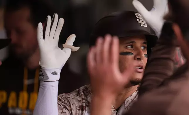 San Diego Padres' Manny Machado celebrates his home run with teammates during the fourth inning of a baseball game against the Chicago White Sox Sunday, May 3, 2026, in San Diego. (AP Photo/Gregory Bull)