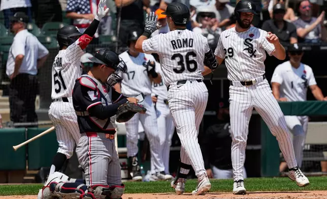 Chicago White Sox's Drew Romo (36) celebrates with Rikuu Nishida (51), of Japan, and Tristan Peters (29) after hitting a two-run home run as Minnesota Twins catcher Alex Jackson reads a memo during the second inning of a baseball game in Chicago, Monday, May 25, 2026. (AP Photo/Nam Y. Huh)