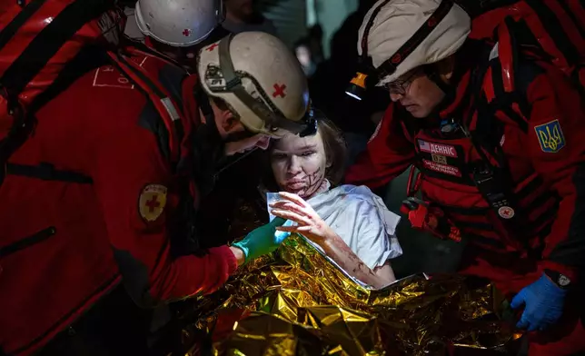 Red Cross volunteers help an injured woman in a shelter after a Russian strike on a residential neighborhood in Kyiv, Ukraine, on Sunday, May 24, 2026. (AP Photo/Evgeniy Maloletka)