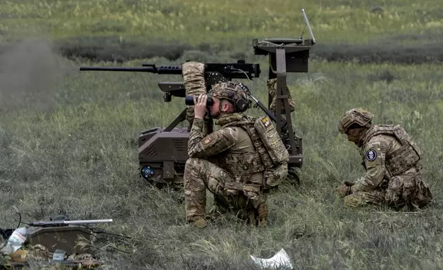 Ukrainian servicemen of the Cerberus Ground Unmanned Systems Company of the 60th Separate Mechanized Brigade, Third Army Corps, conduct a drill with a combat ground drone during a training at the polygon in Kharkiv region, Ukraine, Sunday, May 24, 2026. (AP Photo/Andrii Marienko)