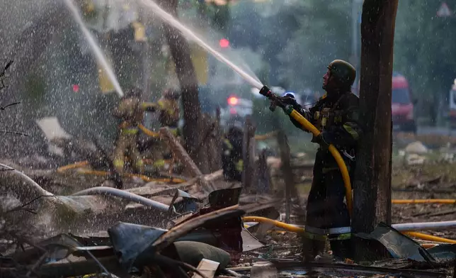 Rescue workers try to put out a fire at a residential building after a Russian strike on Kyiv, Ukraine, on Sunday, May 24, 2026. (AP Photo/Evgeniy Maloletka)
