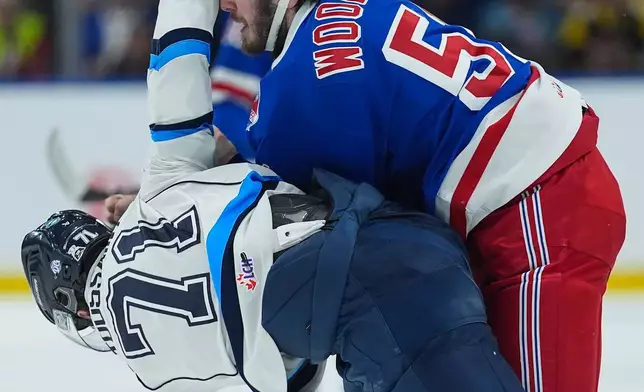 Kitchener Rangers' Jared Woolley, center top, and Chicoutimi Sagueneens' Alexis Toussaint (71) fight during the first period of a Memorial Cup hockey game, in Kelowna, British Columbia, Tuesday, May 26, 2026. (Darryl Dyck/The Canadian Press via AP)