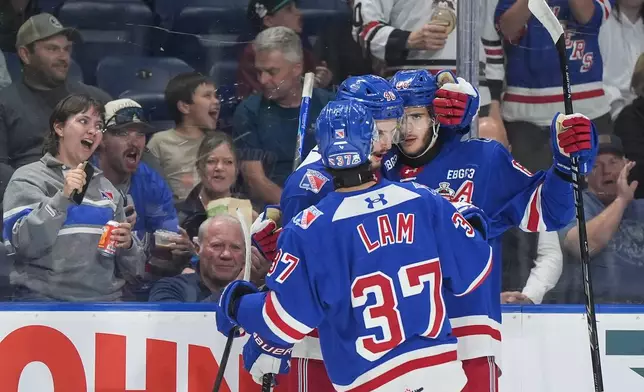 Kitchener Rangers' Luca Romano, back right, Christian Humphreys and Tanner Lam celebrate Romano's goal during the second period of a Memorial Cup hockey game against the Chicoutimi Sagueneens, in Kelowna, B.C., on Tuesday, May 26, 2026. (Darryl Dyck/The Canadian Press via AP)