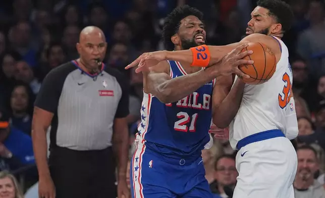 New York Knicks' Karl-Anthony Towns, right, fouls Philadelphia 76ers' Joel Embiid during the first half of Game 1 in a second-round NBA basketball playoffs series Monday, May 4, 2026, in New York. (AP Photo/Seth Wenig)