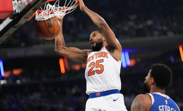 New York Knicks' Mikal Bridges dunks the ball during the first half of Game 1 in a second-round NBA basketball playoffs series against the Philadelphia 76ers Monday, May 4, 2026, in New York. (AP Photo/Seth Wenig)