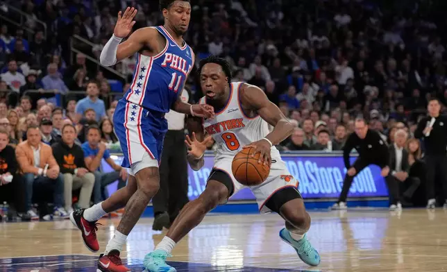 New York Knicks' Og Anunoby, right, drives past Philadelphia 76ers' Justin Edwards during the first half of Game 1 in a second-round NBA basketball playoffs series Monday, May 4, 2026, in New York. (AP Photo/Seth Wenig)