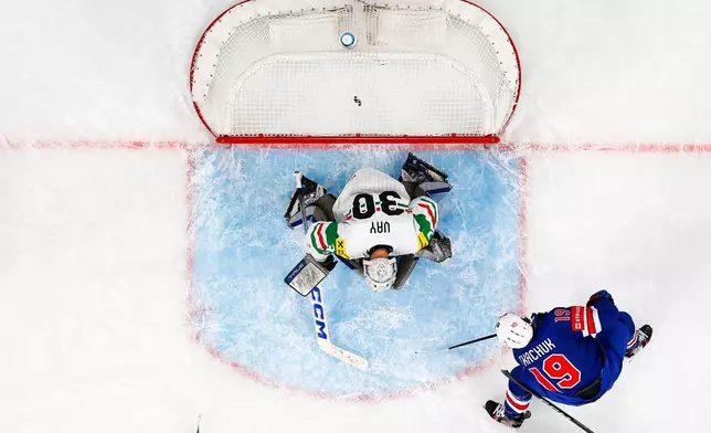 Matthew Tkachuk of the U.S., right, scores against Hungary's goaltender Adam Vay during the 2026 IIHF Men's Ice Hockey World Championship preliminary round group A game between United States and Hungary, in Zurich, Switzerland, Monday, May 25, 2026. (Andreas Becker/Keystone via AP)