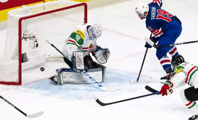 Matthew Tkachuk of the U.S., right, scores against Hungary's goaltender Adam Vay during the 2026 IIHF Men's Ice Hockey World Championship preliminary round group A game between United States and Hungary, in Zurich, Switzerland, Monday, May 25, 2026. (Andreas Becker/Keystone via AP)