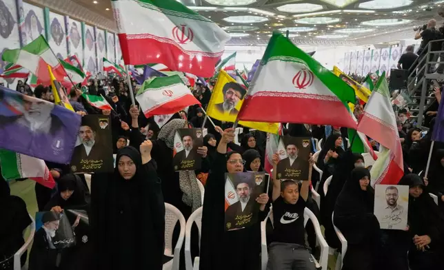 Government supporters hold Iranian flags and pictures of Iran's Supreme Leader, Ayatollah Mojtaba Khamenei, during a ceremony honoring the armed forces and those killed in the war with Israel and the U.S. at the Imam Khomeini Grand Mosque in Tehran, Iran, Sunday, May 24, 2026. (AP Photo/Vahid Salemi)