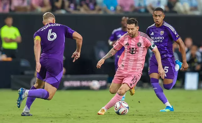 Inter Miami forward Lionel Messi (10) controls the ball as Orlando City defender Robin Jansson (6) attempts to stop and midfielder Luis Otávio (5) looks on in the first half during an MLS soccer match against the Orlando City, Saturday, May 2, 2026, in Miami. (AP Photo/Chris Arjoon)