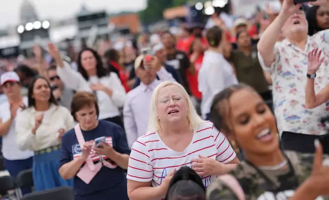 People worship to Christian music at Rededicate 250, a mostly conservative Christian prayer gathering in honor of the United States' 250th anniversary, on the National Mall, Sunday, May 17, 2026, in Washington. (AP Photo/Julia Demaree Nikhinson)