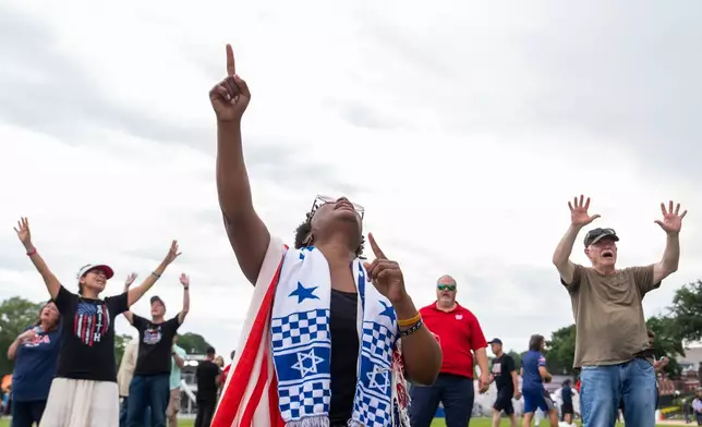 People worship to Christian music at Rededicate 250, a mostly conservative Christian prayer gathering in honor of the United States' 250th anniversary, on the National Mall, Sunday, May 17, 2026, in Washington. (AP Photo/Julia Demaree Nikhinson)